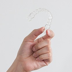 Closeup of patient holding clear aligner