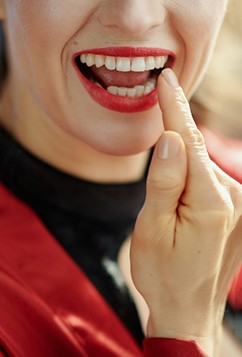 Woman pointing to dental crown in Newburyport