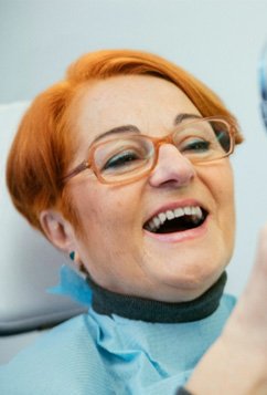 woman looking in a mirror in a dentist chair 