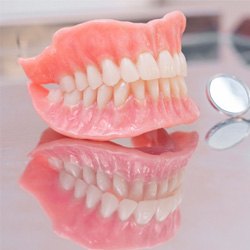full dentures next to dental instruments 