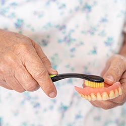 Woman brushing her dentures