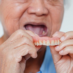 Woman holding dentures
