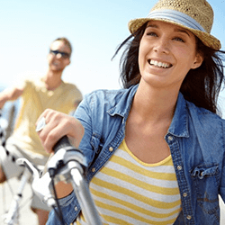 a woman with dental implants riding a bicycle