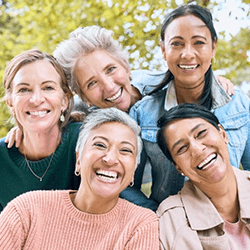 a mature woman with dental implants spending time with friends
