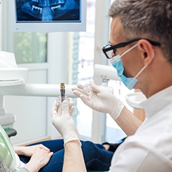 dentist showing a dental implant to a patient 