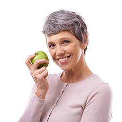 smiling woman holding green apple 