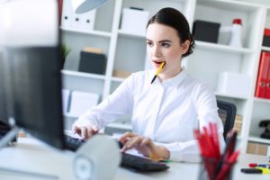 Busy woman chewing on a pen. 