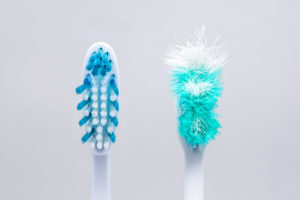 Juxtaposed old & new toothbrush prompts the question "When should I change toothbrushes?"