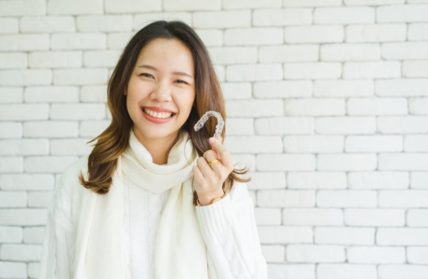 Woman holding her Invisalign tray.