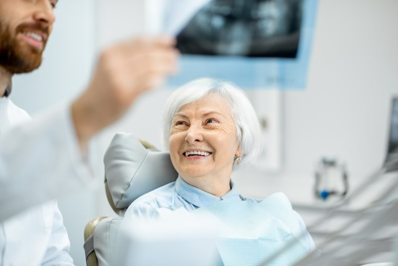 dentist explaining difference between partial dentures and dental bridges